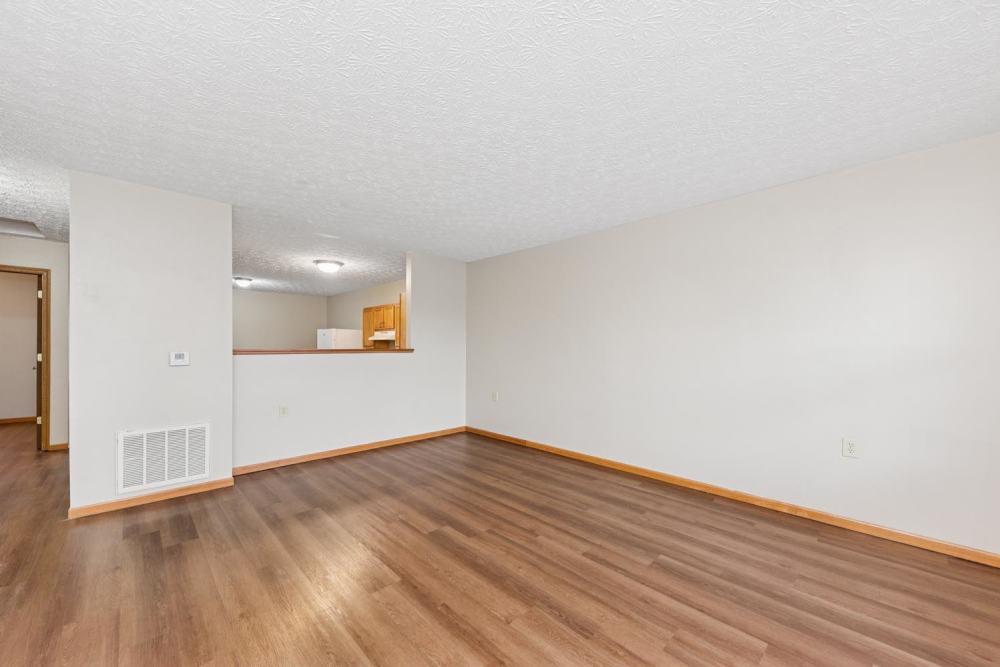 Living area with wood-style flooring and open layout leading to kitchen at Webster Glen in Peebles, Ohio