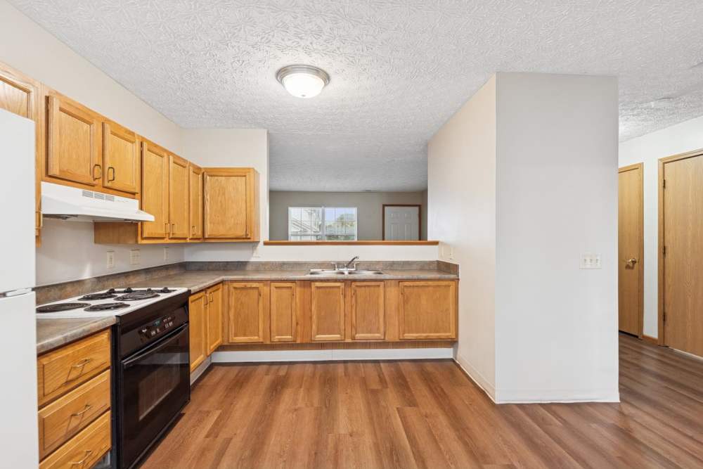 Kitchen with wood-style flooring and wooden cabinets at Webster Glen in Peebles, Ohio