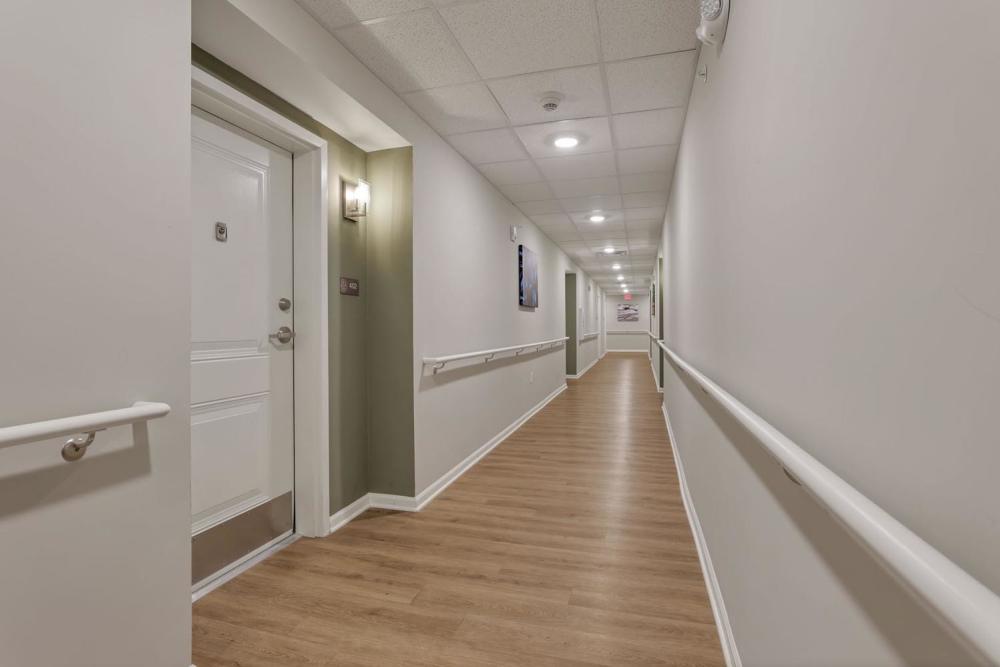 Long hallway with wooden flooring and handrails at McKinley Manor in Columbus, Ohio