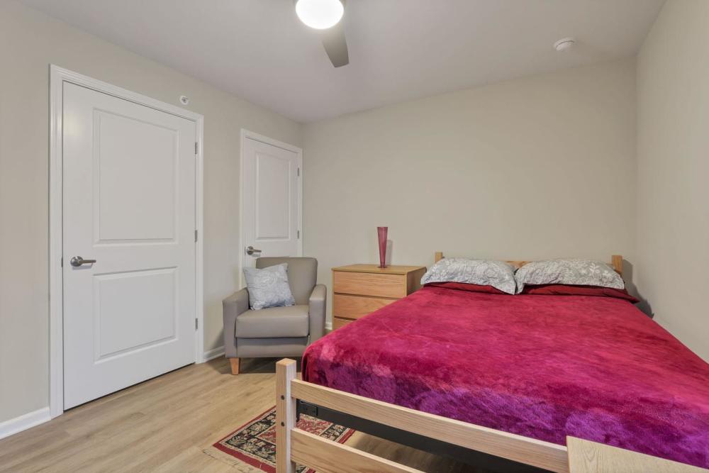 Bedroom with a bed and an arm chair at McKinley Manor in Columbus, Ohio 