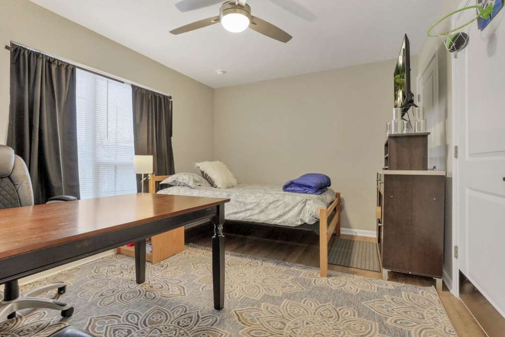 Bedroom with a cozy bed and a ceiling fan at McKinley Manor in Columbus, Ohio 