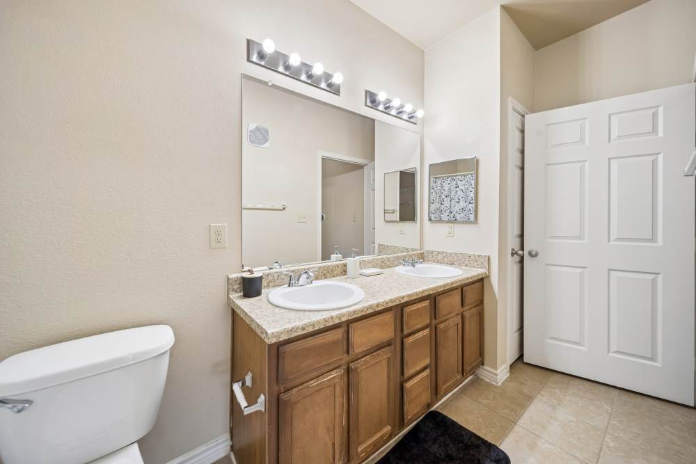 Commode and dual vanity sinks in bathroom at Blue Ridge in Midland, Texas