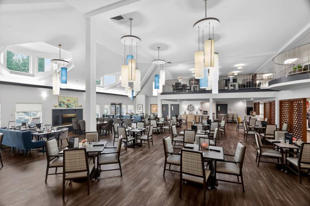 Large dining room with multiple tables and chairs, high ceiling, and modern pendant lights at Whealdon Estates by Barclay House in Baton Rouge, Louisiana  