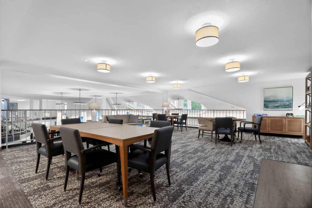 Upper-level lounge with tables, chairs, railing, and carpeted floor overlooking below at Whealdon Estates by Barclay House in Baton Rouge, Louisiana  