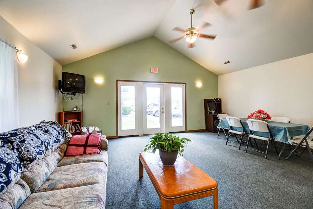 Bright community lounge with comfortable seating, dining area, and large windows for natural light at Catawba Club in Berkeley Springs, West Virginia