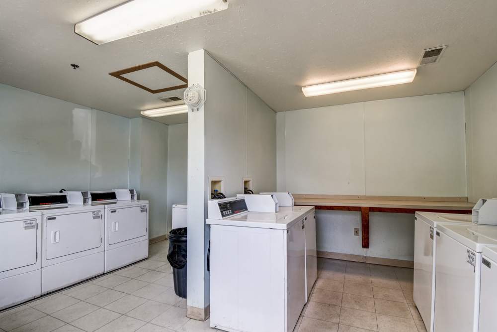 Bright laundry room for the residents with multiple washing machines and dryers, spacious folding area, clean and well-lit at Catawba Club in Berkeley Springs, West Virginia