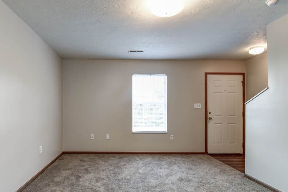 Spacious living area with carpet flooring and natural light from window at Cedar Glen I in Morgantown, West Virginia