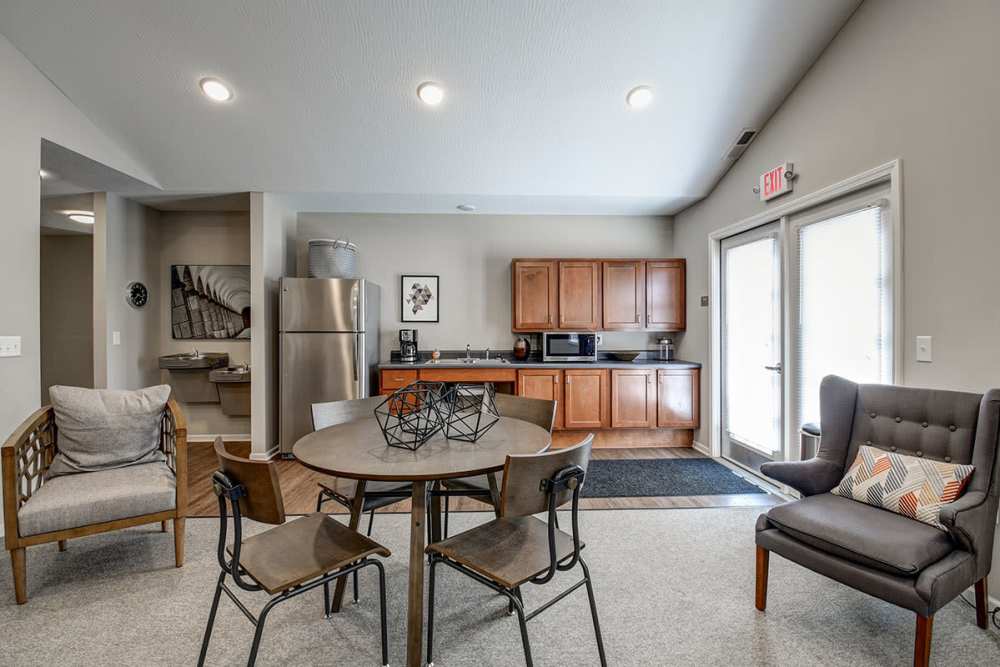 Open layout clubhouse kitchen with stainless steel appliances, dining area, and cozy seating options at Labelle Greene I in Wheeling, West Virginia
