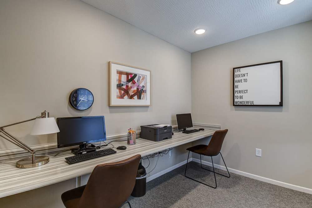 Modern workspace with two desks, computers, and decorative wall art in neutral tones at Labelle Greene I in Wheeling, West Virginia