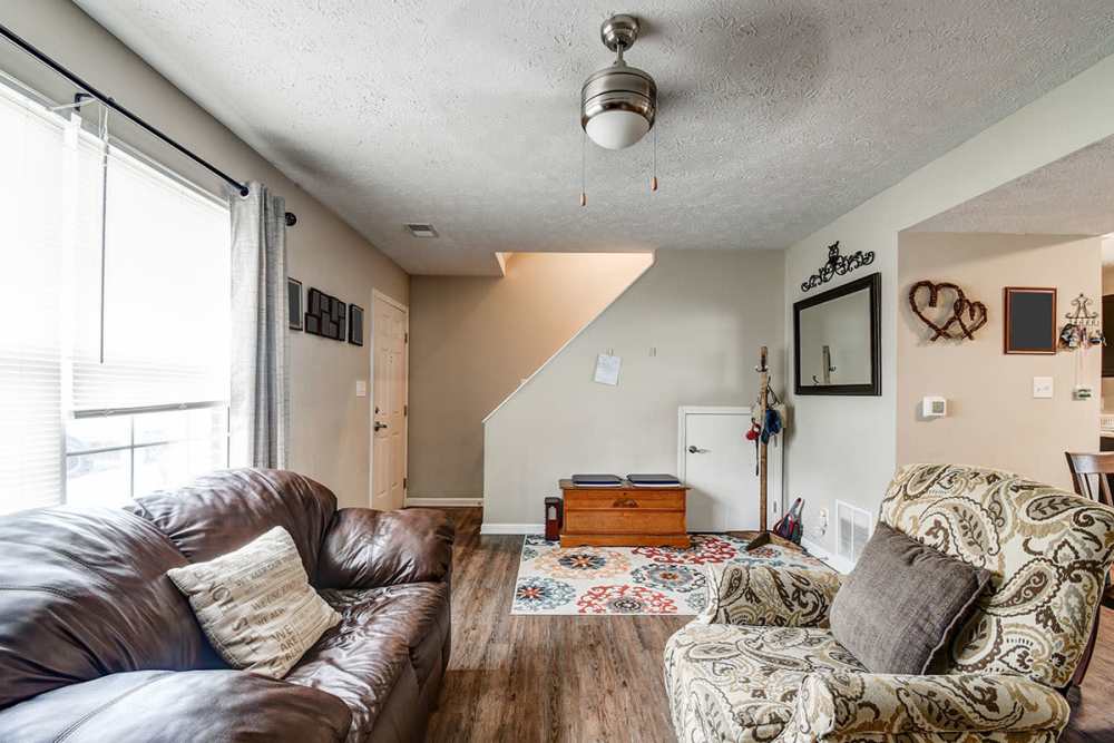 Cozy living room with wood-style flooring, large windows, and comfortable seating options at Terrapin Park in Parkersburg, West Virginia