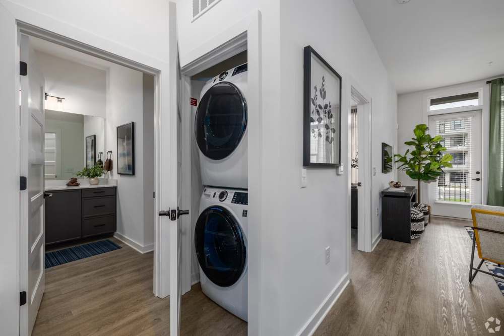 In-unit laundry with stacked washer and dryer and hallway access at The Millwright in Cornelius, North Carolina