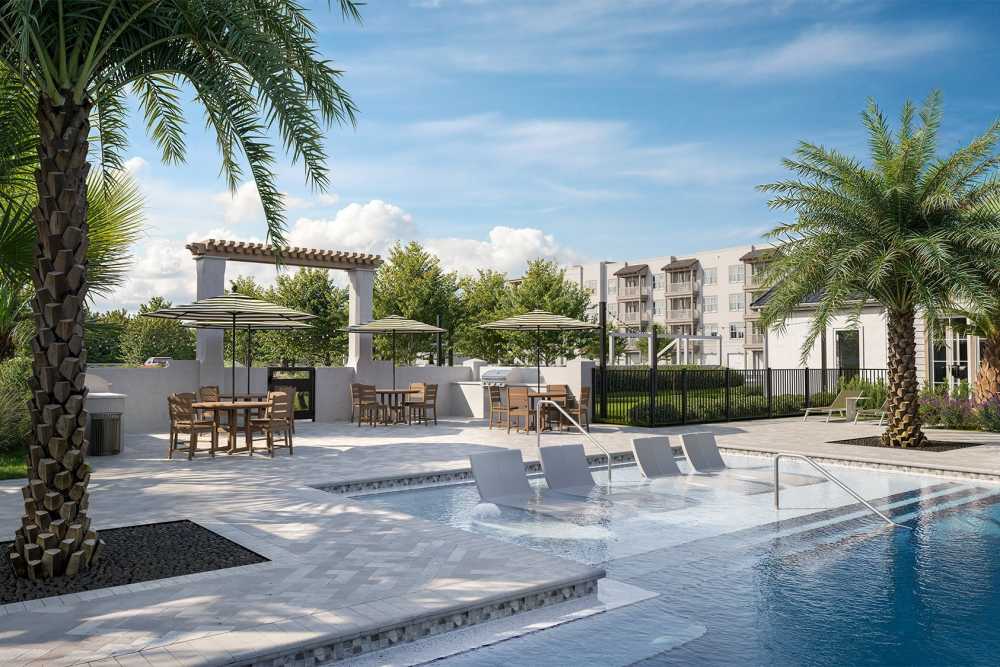 Pool area with lounge chairs  at Romero Apartments in Pensacola, Florida