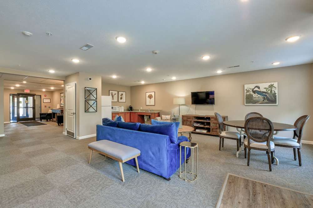 Spacious community room with a cozy couch and a TV at Willoughbeach Terrace Senior Living in Willowick, Ohio 