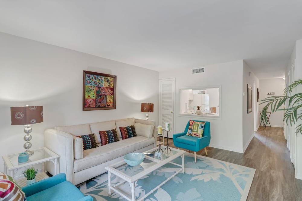 Spacious living room with plush carpeting, couche coffee table at Carlton Arms Of Winter Park in Winter Park, Florida