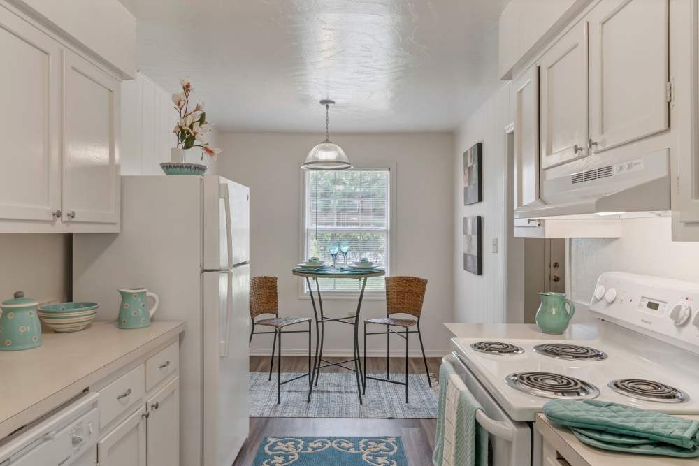 Kitchen island with dishwasher, sink with waterfall faucet, and granite countertops at Carlton Arms Of Winter Park in Winter Park, Florida
