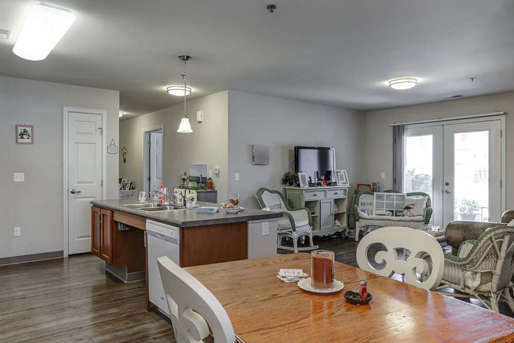 Open layout kitchen with granite countertops and stainless steel appliances, cozy living area with seating at Brookside Commons in Traverse City, Michigan