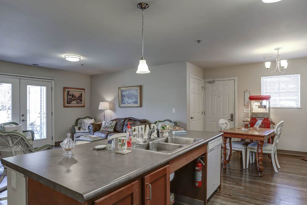 Open layout kitchen with stainless steel appliances and granite countertops, cozy living area with comfortable seating at Brookside Commons in Traverse City, Michigan