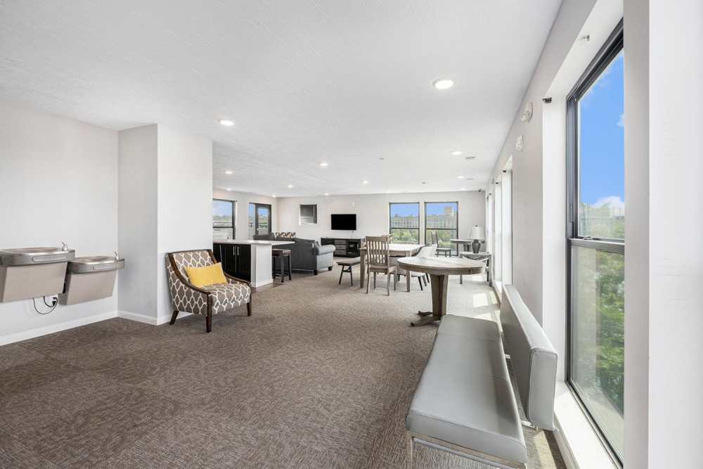 Bright community lounge with seating, large windows, and water fountains, perfect for social gatherings at Grand View Place in Grand Rapids, Michigan