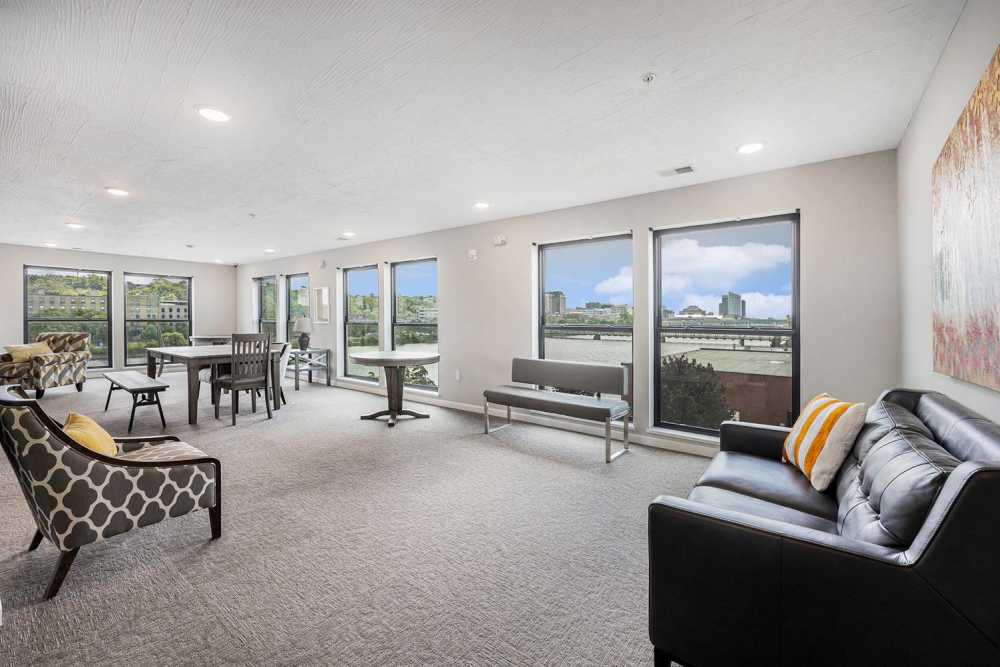 Bright community lounge with large windows, modern furniture, and scenic views of the outdoors at Grand View Place in Grand Rapids, Michigan