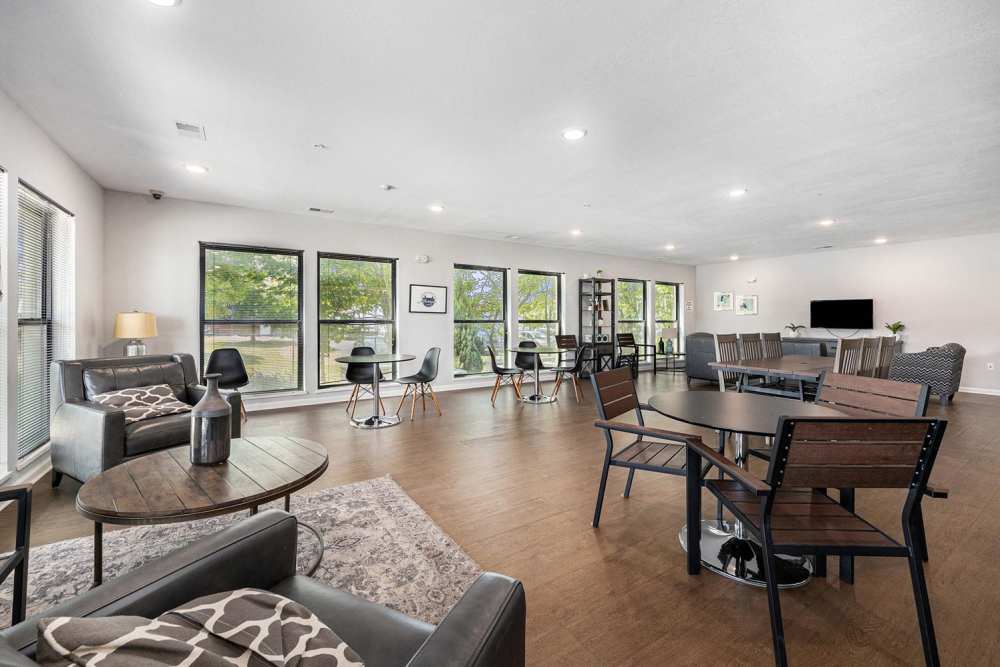 Community lounge with large windows overlooking greenery at Grand View Place in Grand Rapids, Michigan