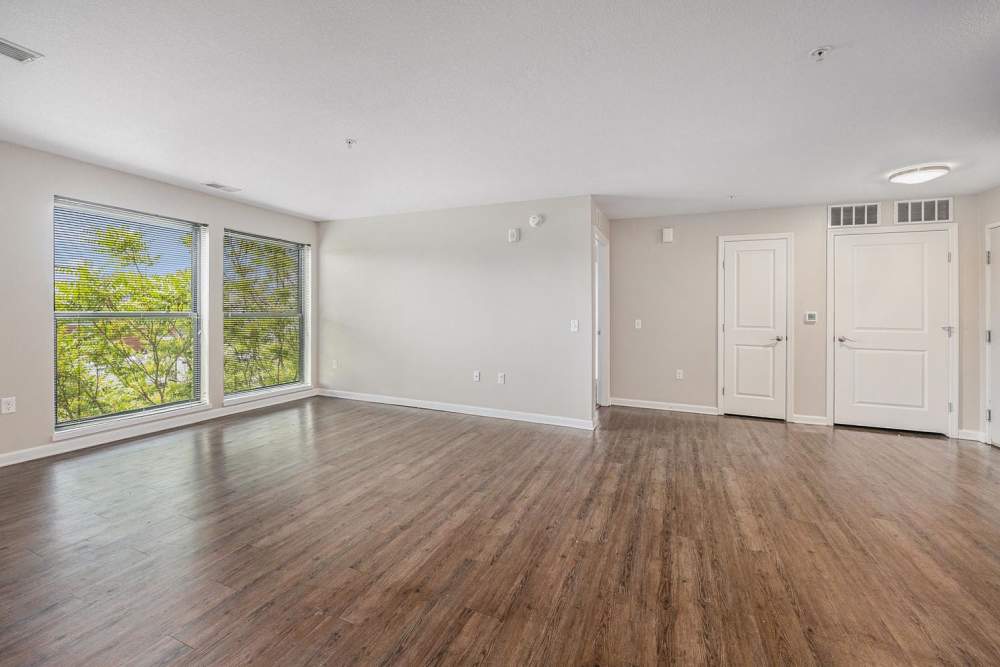 Spacious living area with wood-style flooring and large windows for natural light at Grand View Place in Grand Rapids, Michigan