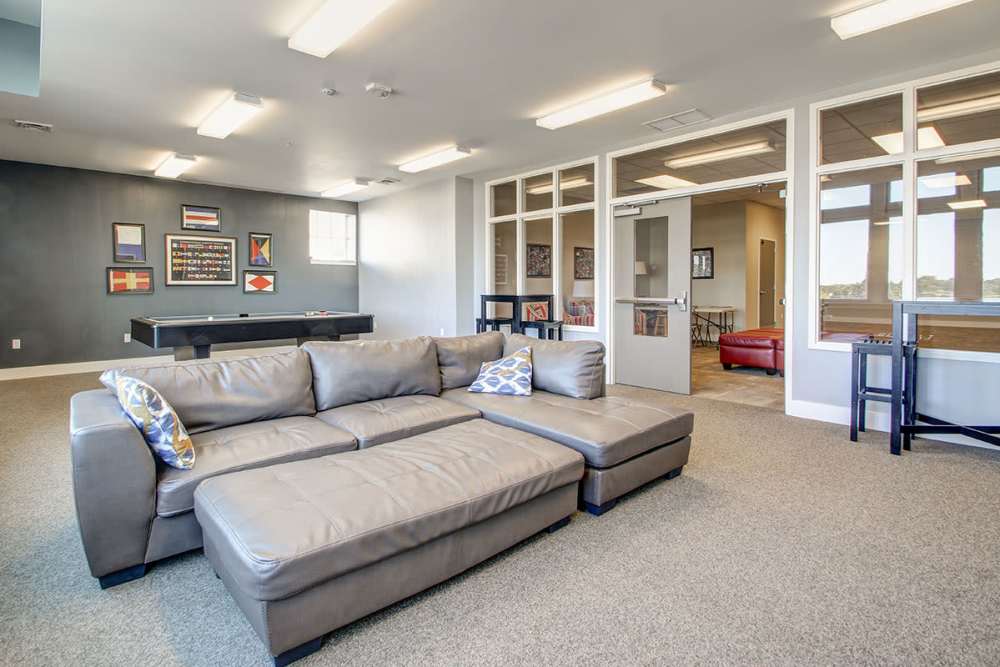 Spacious lounge area with sectional sofa, pool table, and large windows for natural light at Lloyd House I in Menominee, Michigan