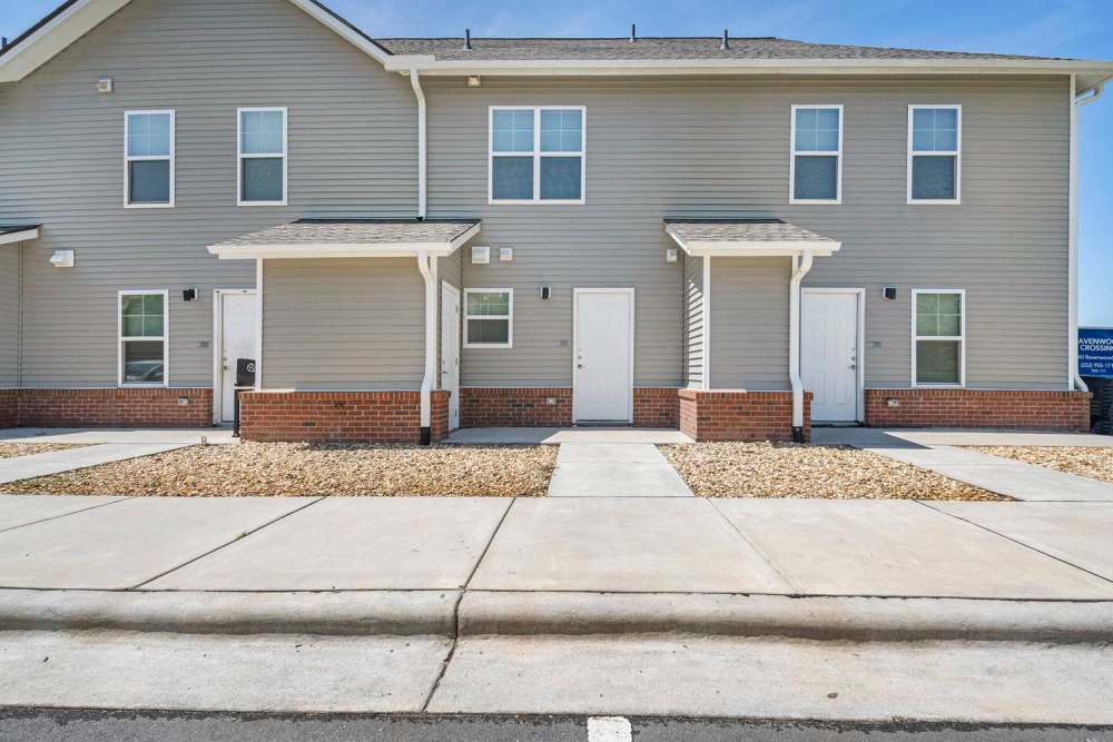 Two-story apartment community with welcoming entrances and landscaped pathways at Ravenwood Crossing in Rocky Mount, North Carolina