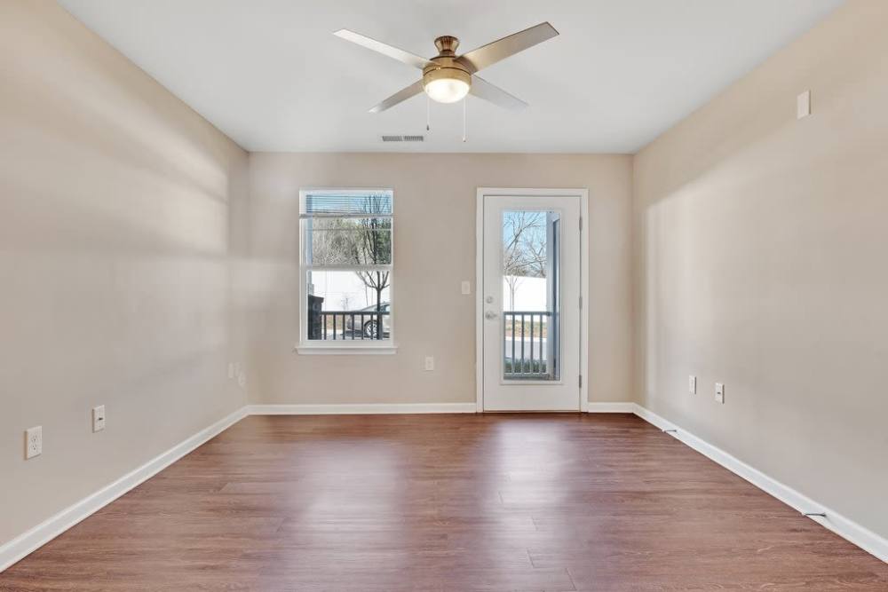Spacious living area with ceiling fan, access to outdoor balcony at Rivergate Greene in Charlotte, North Carolina