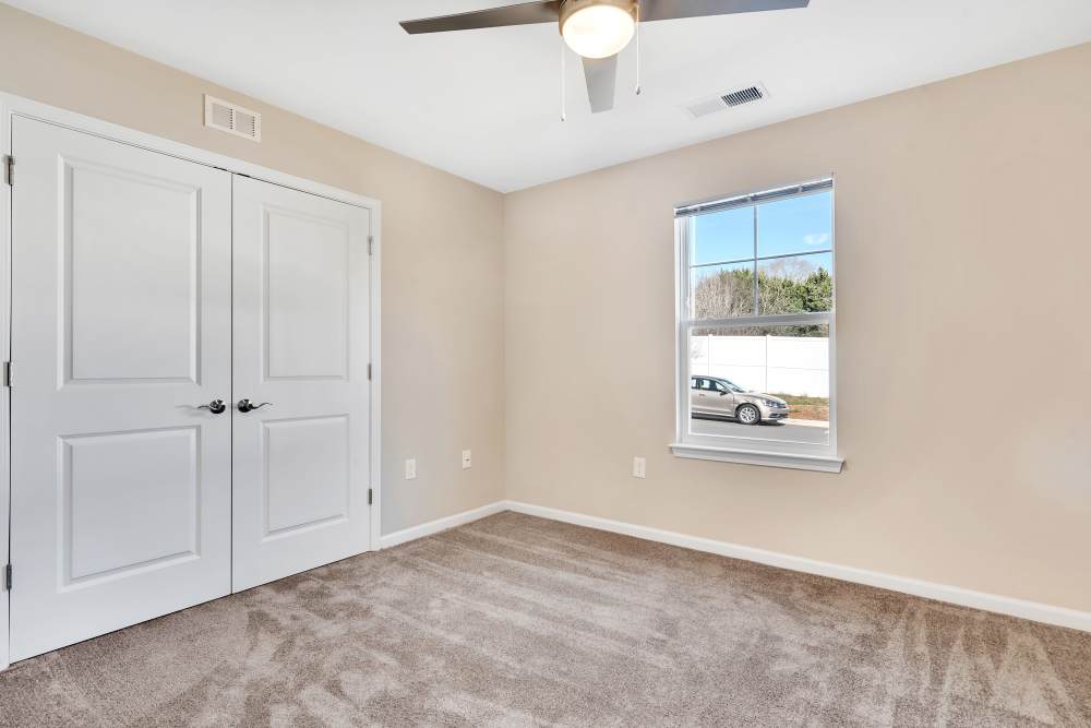 Spacious bedroom with large window, and double closet doors at Rivergate Greene in Charlotte, North Carolina