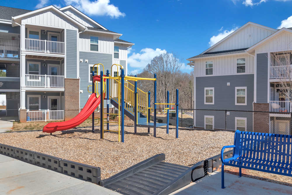 Playground with slide and blue bench at Rivergate Greene in Charlotte, North Carolina