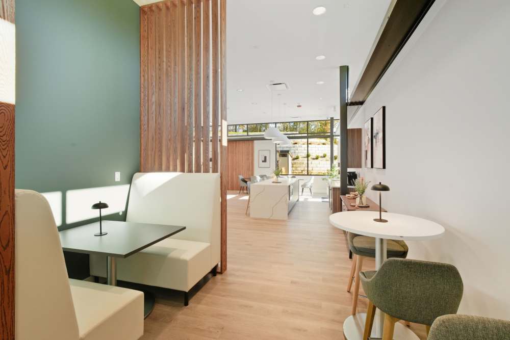 Modern clubhouse lounge with seating and cafe tables at Eagle Rock Apartments at Woodbury in Woodbury, New York