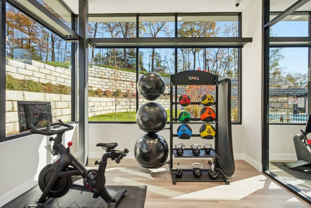 Apartment fitness area with weights and exercise bike at Eagle Rock Apartments at Woodbury in Woodbury, New York