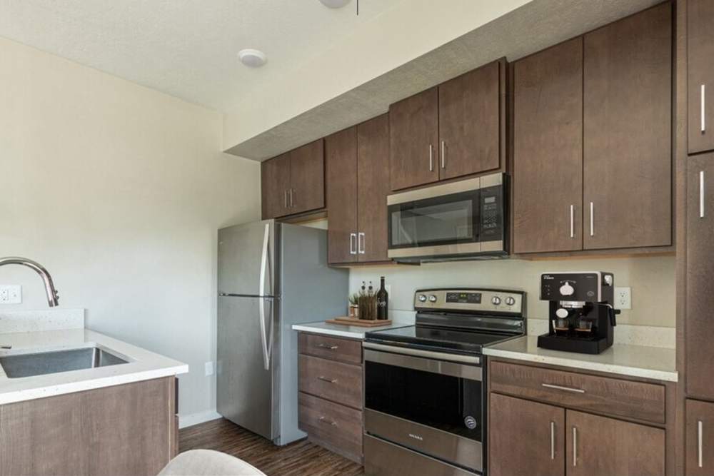 Kitchen with wooden cabinets and stainless-steel appliances at The Enclave in Meridian, Idaho