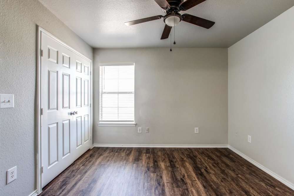 Empty bedroom with wood-style flooring at Tuscany Court Townhomes in Hondo, Texas