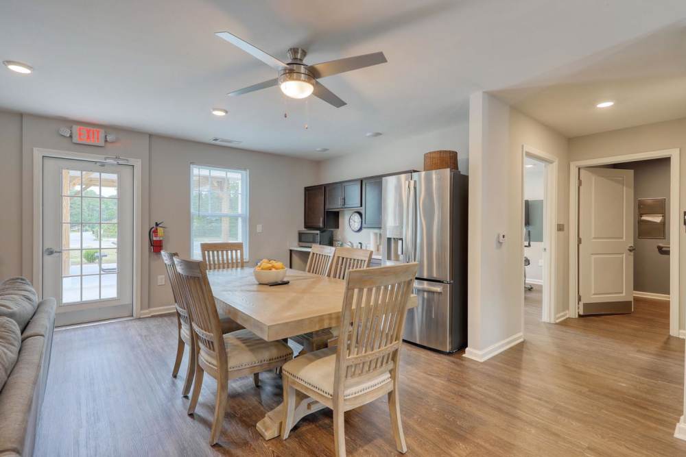 Dining area with wood-style flooring inside the clubhouse at Harbor Meadows in Calabash, North Carolina