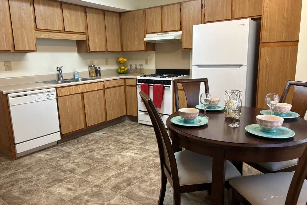 Kitchen with wooden cabinetry and white appliances at MeadowView Townhomes in Goshen,Ohio