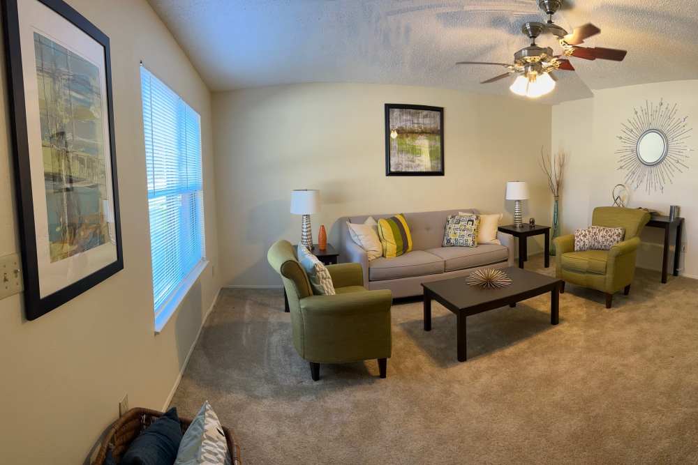 Living room with a fancy ceiling fan and carpet flooring at MeadowView Townhomes in Goshen,Ohio