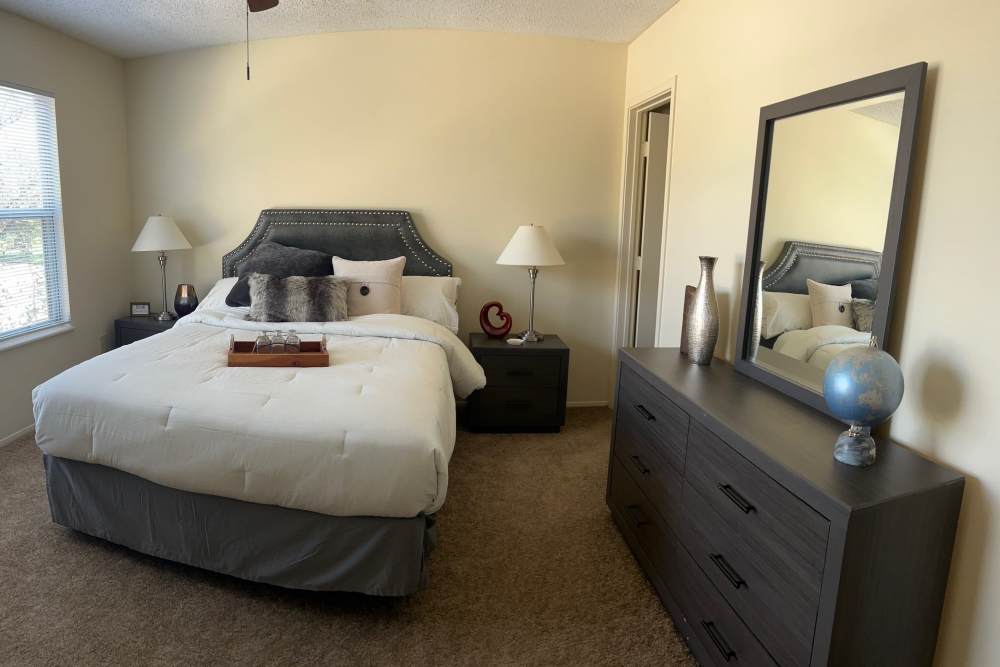 Apartment bedroom with a spacious bed and a mirror at MeadowView Townhomes in Goshen,Ohio