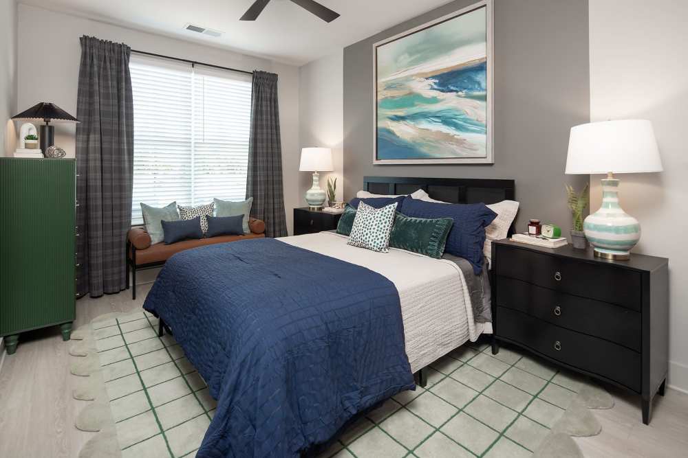 Modern bedroom with expansive windows, spacious closet, and stylish ceiling fan at Cypress Point Luxury Apartments in Mooresville