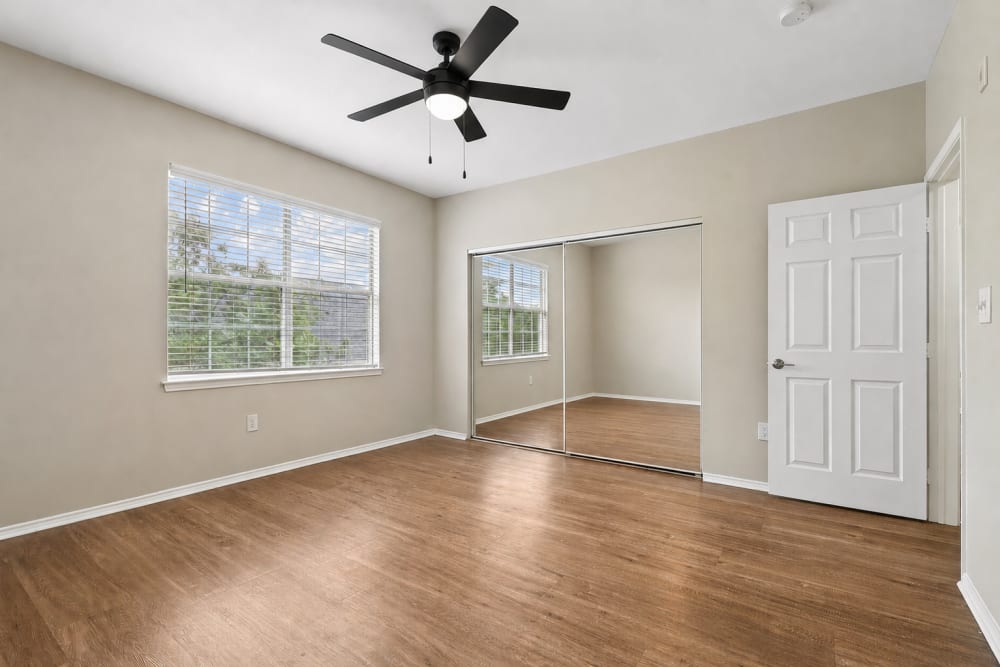 Unfurnished spacious bedroom with mirrored closet doors at Breckinridge Point Apartments in Richardson, Texas