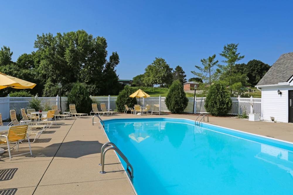 Community swimming pool with deck seating, umbrellas, and clear blue water at Ashton Glen in Centerville, Ohio