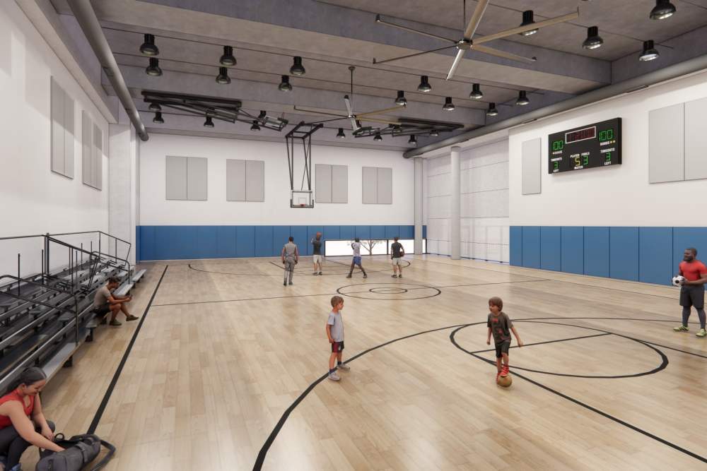 Indoor basketball court at The Exchange at Spring Hill Station with full court layout, seating, and modern fitness amenities