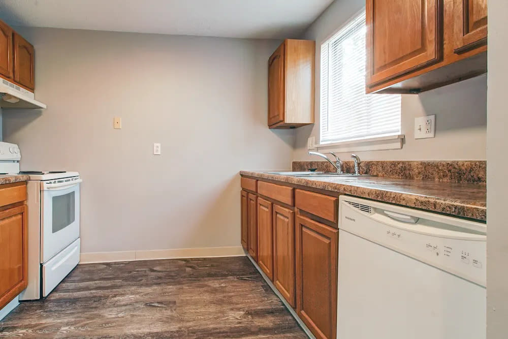 Kitchen with wooden cabinets at North Dohr Apartments in Rochester, New York