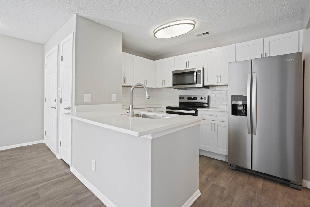 Cozy kitchen with stainless-steel appliances including refrigerator at Niner Woods in Charlotte, North Carolina