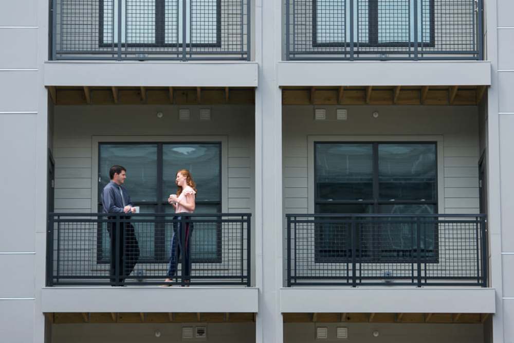 Residents talking on their balcony at Harlan Flats in Wilmington, Delaware
