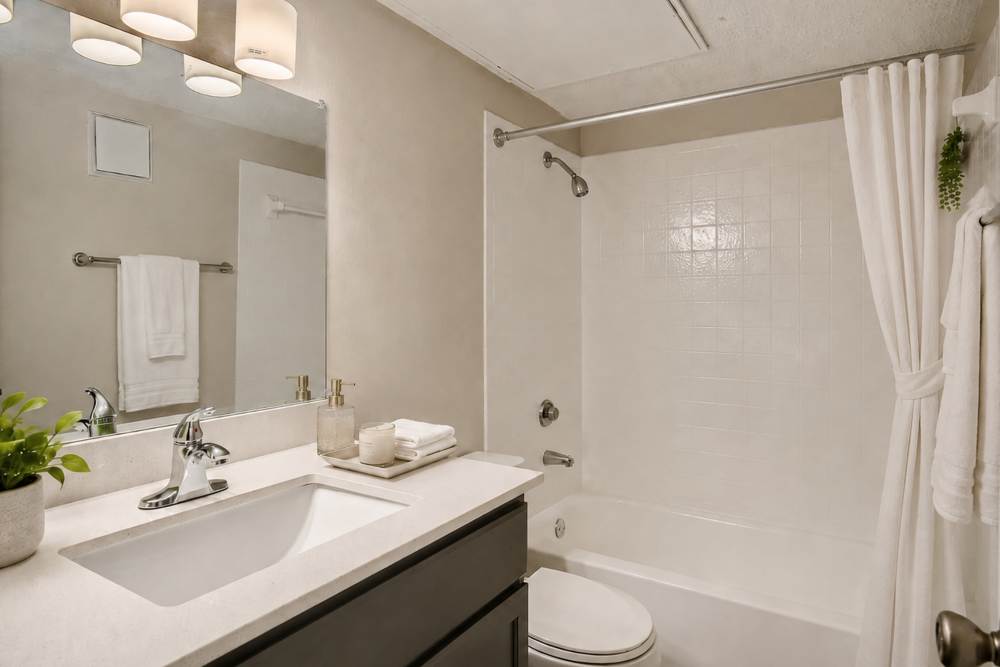 Bathroom with large mirror at Rochelle Plaza in Irving, Texas