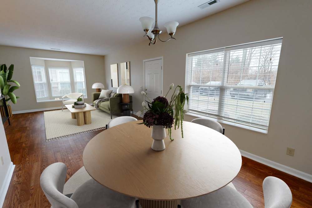 Dining area with round table and modern chairs at Whispering Wind Apartments & Townhomes in Newtown, Ohio