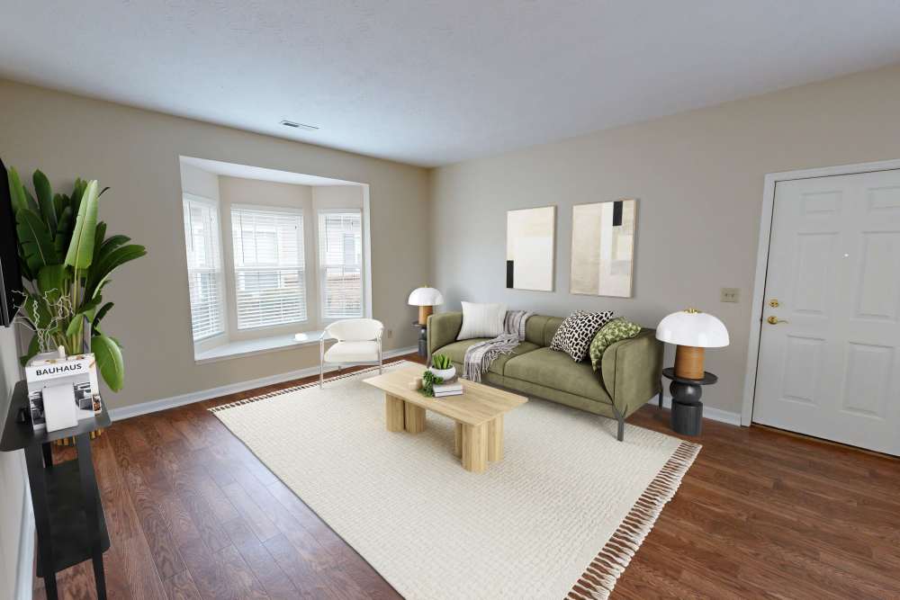 Cozy living room with wood-style flooring and natural light at Whispering Wind Apartments & Townhomes in Newtown, Ohio