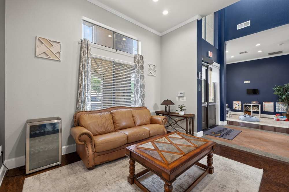 Cozy lounge area with leather sofa at Rosemont At Lakewest in Dallas, Texas