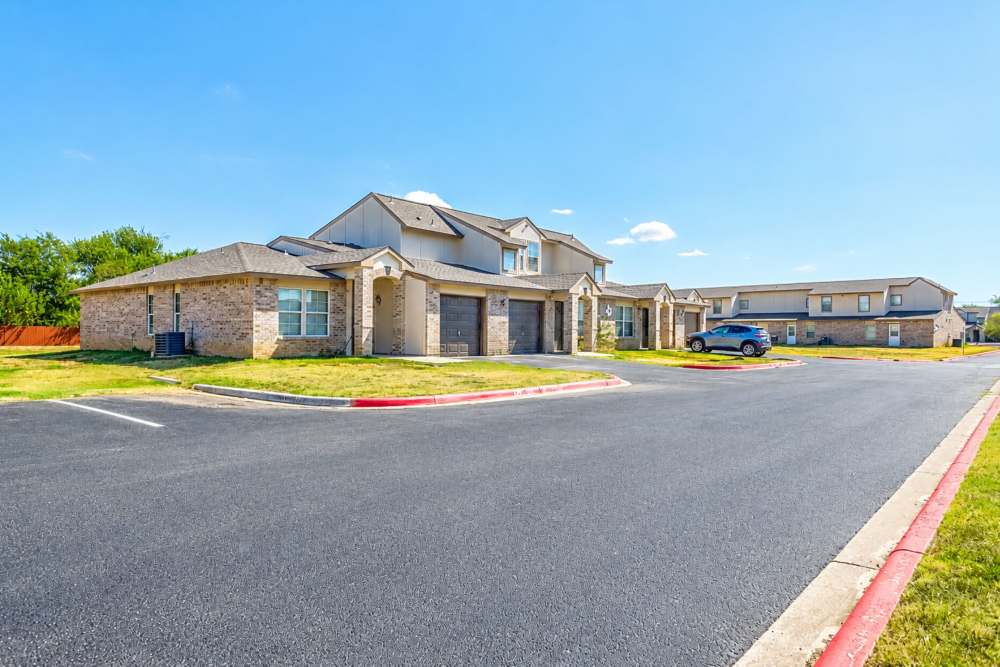 Apartment building exterior with parking at Tuscany Court Townhomes in Hondo, Texas